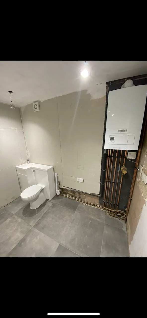 Finished room with Vaillant boiler, toilet and basin unit, tiled floor