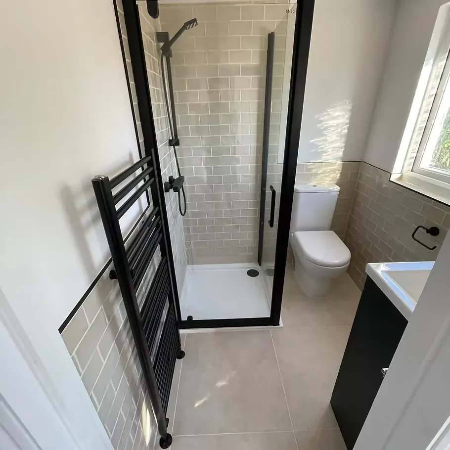 Shower room with black-framed enclosure, sage metro tiles and black towel radiator