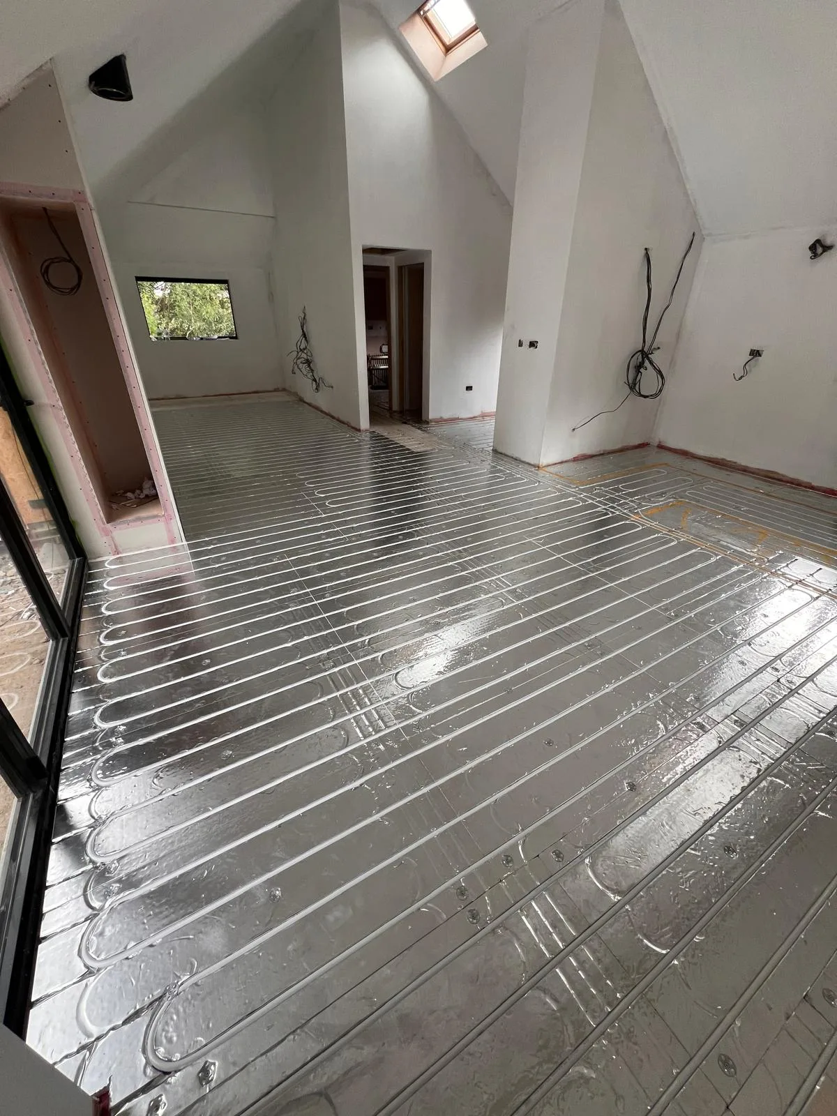 Underfloor heating pipe loops laid out across the floor